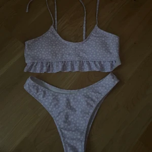 Ljuslila blommig bikini med volang - Superfin ljuslila bikini med små vita blommor! 
