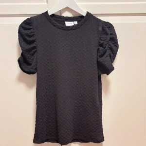 Svart blus med puffärm från Vila💕 - Säljer en snygg svart blus från Vila i storlek xs. Själv har aldrig använt den, bara testat.💕