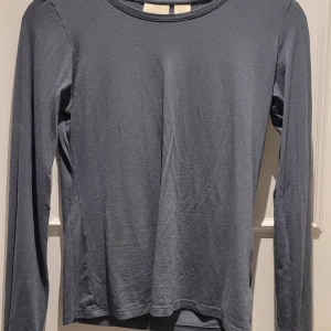 Mörkgrå långärmad tröja Telluride - Mörkgrå långärmad tröja från USA vek ej märke. Tröjan har en klassisk rund halsringning och är av otroligt mjukt material. Storlek XS men passar även S beroende på hur tight man vill ha plagget. 