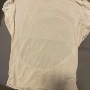 Vit topp med öppen rygg - En enkel vit topp i mjukt material med korta ärmar och en stor öppen rygg. Perfekt för dig som gillar minimalistisk stil och vill visa lite extra hud på ryggen. Passar snyggt till både jeans och kjol.