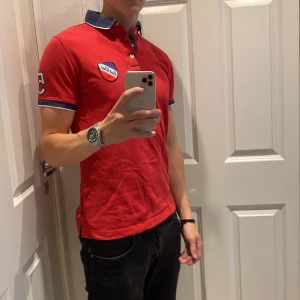 Röd pikétröja från East West - Snygg röd pikétröja från East West. Bara att höra av sig vid minsta fråga eller funderingar, pris kan diskuteras!🍾🤗