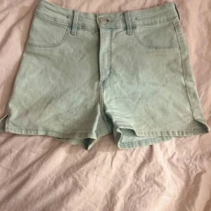 Ljusblå jeansshorts med fickor - Snygga ljusblå jeansshorts med klassisk femficksdesign och bälteshällor. Shortsen har en rak passform och är perfekta för varma dagar. Stängs med knapp och dragkedja framtill. Enkla att matcha med allt i garderoben.