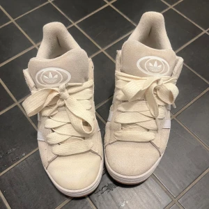 Beige Adidas Campus sneakers mocka - Superfina Adidas Campus ✨ Säljer dessa beiga Adidas Campus med vita ränder som tyvärr inte kommer till användning 💗superskick och ser nästan helt nya ut!Storlek 39, men passar även dig som brukar ha 38. Kommer utan box, men med ett par fräscha vita skosnören. Nypris ca 1100 kr du får dem för 350kr Skriv gärna om du vill ha fler bilder eller har frågor!💕