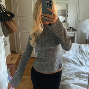 Glittrig ribbad grå tröja - Supersnygg glittrig ribbad topp, perfekt till fest!💖 Tröjan har en figurnära passform och lätt utsvängda ärmar. Nytt skick med prislapp kvar