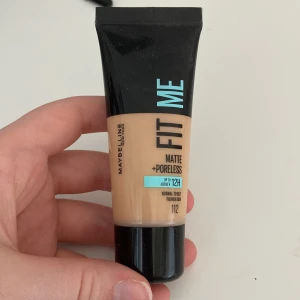 Maybelline Fit Me Foundation 112 - Maybelline Fit Me Matte + Poreless Foundation i nyansen 112. Flytande foundation som ger en matt finish och minimerar porer. Passar normal till oljig hud. Kommer i en smidig tub på 30 ml med svart lock och beige färg.