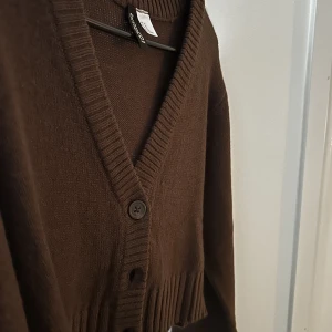 Kofta - Säljer denna bruna croppade koftan från h&m då den inte kommer till användning längre, perfekt nu till hösten! Använd endast 1-2 gånger