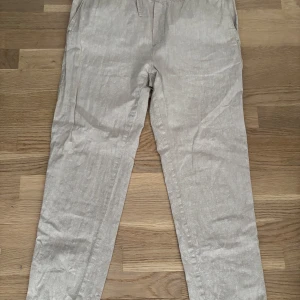 Beige linnebyxor från Cubus, storlek L - Snygga beige linnebyxor från Cubus i storlek L. Byxorna har elastisk midja, raka ben och är gjorda i en skön blandning av linne och bomull. Perfekta för en chill och avslappnad stil under varmare dagar.