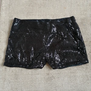 Svarta paljettshorts från VILA - Glittriga svarta shorts från VILA, täckta med paljetter för en riktigt festlig look!🖤