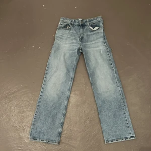 Blå raka jeans från Calvin Klein Jeans - Säljer ett par klassiska blå jeans från Calvin Klein Jeans med rak passform. Jeansen har fem fickor, normal midja och stängs med dragkedja och knapp. Perfekta för en avslappnad och stilren look.