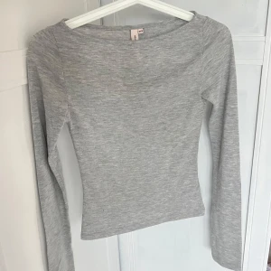 Ljusgrå långärmad topp - Säljer en enkel och stilren ljusgrå långärmad topp från Nelly. Modellen är tight och har en rund halsringning. Otroligt mjukt tyg och aldrig använd!💓💓
