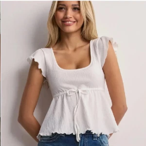 Vit blus Nelly - Vit blus/topp ifrån Nelly, köpt förra sommaren och använd några fåtal gånger.