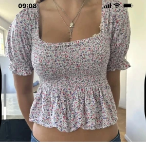 Blommig smockad blus med puffärm - Supersöt blommig blus med smockad överdel och volang nertill. Är i väldigt bra skick!!💓💓(lånad bild)
