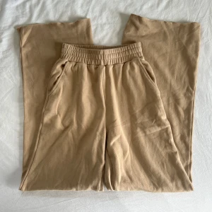 Bruna mjukisbyxor från Bik Bok - Säljer ett par bruna mjukisbyxor från Bik Bok med resår och snörning i midjan. Byxorna har breda snygga ben och sidofickor och är i strl S