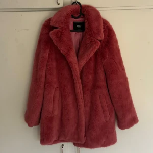 Rosa fuskpälsjacka  - Säljer en fluffig och trendig rosa fuskpälsjacka. Jackan har lång ärm, bred krage och två fickor framtill. Har endast används 1 gång sen den köptes och är i nyskick utan defekter. Jackan ser längre ut på bild än i verkligheten och riktiga färgen framhävs bäst på sista bilden. Skriv privat för fler bilder. 💕