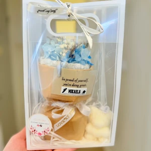  presentförpackning med blå blommor -  presentförpackning med dekorativa blå och vita torkade blommor. Förpackningen har fina band med text och etikett, samt en liten papperspåse. Perfekt som gåva till någon speciell.