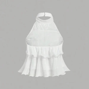 Vit volangig halterneck topp - Säljer en vit halterneck topp med flera lager volanger. Toppen har en hög hals med knäppning i nacken och är ärmlös. Perfekt för dig som vill ha en luftig och trendig look.