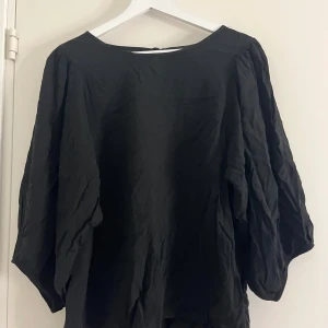 Svart blus med trekvarts armar - En svart blus med trekvarts armar i storlek M men passar som L, bra passform och väldigt stilren!