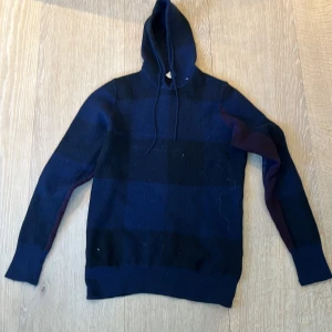 Mörkblå hoodie från Burberry Brit - Säljer en mörkblå hoodie från Burberry Brit i storlek M. Den har dock tyvärr krympt i tvätten så ny sitter den mer som Xs.Tröjan har ett diskret rutmönster. Materialet är riktigt tjockt och varmt, perfekt för kyligare dagar. Klassisk och stilren design med förstärkta armbågar.