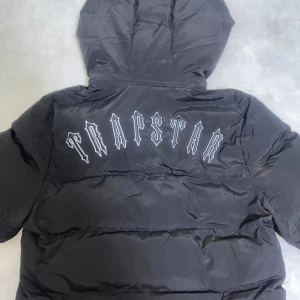 Trapstar jacka - Trapstar jacka. Storlek S. Jackan är i väldigt bra skick och har inte använts på ett bra tag därför ska jag sälja den.  Litet defect på luvan när man gör den mindre och större men funkar som den ska som visas i sista bilden
