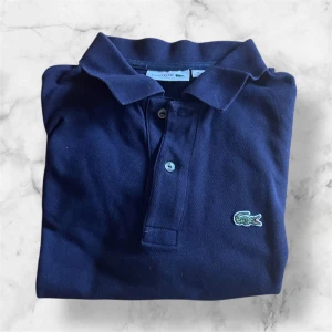 Mörkblå pikétröja från Lacoste - Denna härliga piké från Lacoste säljs nu!! Den är i toppkvalitet utan tecken på defekter. Storlek M, men passar S också! Helt perfekt nu inför sommaren och våren‼️(kan gå ner mycket i pris vid snabb affär! Typ 175kr totalpris ifall man är snabb!)