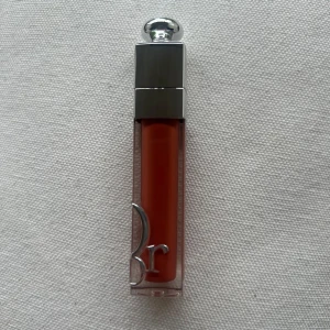 Dior Addict Lip Maximizer 039 - Säljer ett Dior Addict Lip Maximizer i färgen 039. Det är ett läppglans med en snygg orange-korall nyans och glansig finish. Kommer i en lyxig genomskinlig hylsa med silverdetaljer och Dior-logga på locket. Kommer utan förpackning, oanvänd och otestad, om du köper fler av dessa läppstift kan jag tänka mig bättre pris. Rensning inför flytt