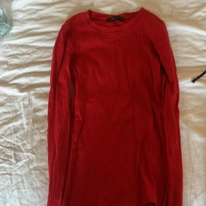 Röd ribbad långärmad tröja från New Yorker  - Säljer en tight, ribbad långärmad tröja från New Yorker i en snygg röd färg. Perfekt att styla till jeans eller kjol. Tröjan har rund halsringning och sitter figurnära. Säljer pågrund av dålig andväning.💖