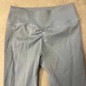 Ljusblå sömlösa leggings - Snygga ljusblå leggings med medium hög midja och ribbade detaljer längs sidorna. Sömlös design och lätt rynk bak för extra passform. Perfekta för träning eller en aktiv vardag. Från Linn Lowes märke Stacci Athletics 