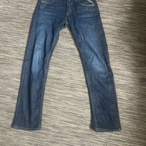 Blå raka jeansbyxor - Klassiska blå jeansbyxor med raka ben och femficksmodell. Byxorna har normal passform och synliga sömmar vid fickor och bakfickor. Perfekta till vardags och passar till det mesta. W31 L32, straight fit, grover.