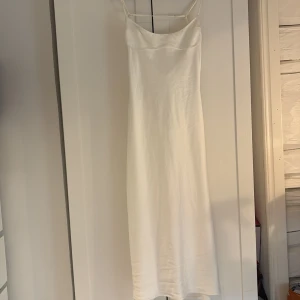Vit satinklänning från Zara - Säljer en elegant vit långklänning från Zara i satin med smala axelband och slimmad passform. Klänningen har en enkel och stilren design med lätt glansigt material som ger en lyxig känsla. Perfekt för sommarens speciella tillfällen eller till student och skolavslutning! Hör av dig vid intresse!💕