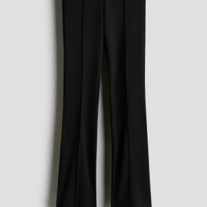 Svarta byxor med pressveck - Klassiska svarta byxor med pressveck och rak passform. Perfekta för en stilren och clean look. Byxorna har hög midja och vida ben som ger en snygg siluett.