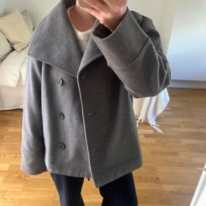 Grå vårkappa - Grå kappa från Gina tricot i bra skick då den använts fåtal ett fåtal gånger 