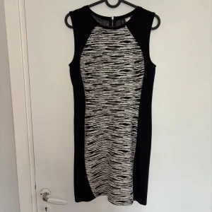 Svart/vit mönstrad ärmlös klänning - En snygg ärmlös klänning från Divided by H&M i svart och vitt med mönster framtill och baktill. Klänningen har en tight passform och dragkedja i ryggen. Plagget har storleken M men passar S likaså! 🖤