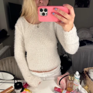 Vit stickad tröja med fluffig struktur - Säljer en vit stickad tröja med rund hals och lång ärm. Tröjan har en fluffig och mjuk känsla, perfekt för kyligare dagar. Enkel och stilren design som passar till mycket.