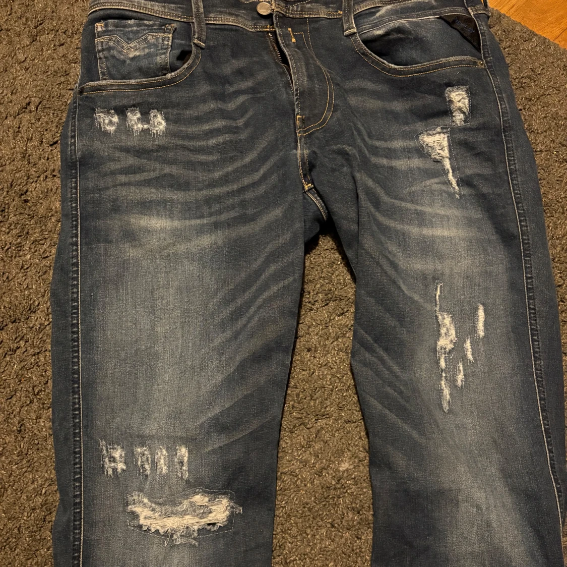 Blå slitna jeans med raka ben