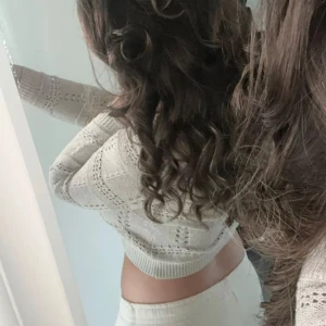 Off shoulder tröja  - Säljer en vit croppad stickad tröja med hålmönster och långa ärmar. Tröjan har en ribbad kant vid midjan och är perfekt för en trendig och avslappnad look. Stl XS/S