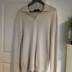 Beige stickad pikétröja från Riley - Säljer en stilren beige stickad pikétröja från Riley. Perfekt för dig som gillar en enkel men snygg look. Storlek M, knappt använd så den är i väldigt bra skick. Säljer för 600kr men pris kan diskuteras vid snabb affär