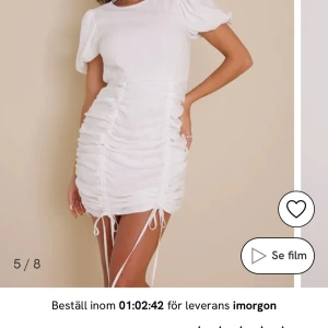 Vit kortklänning med puffärm och rynkade detaljer - Superfin vit kortklänning med puffärmar och rynkade detaljer längs sidorna. Klänningen har rund halsringning och snörning nertill för justerbar längd. perfekt till studenten 💗 aldrig använd lappar kvar