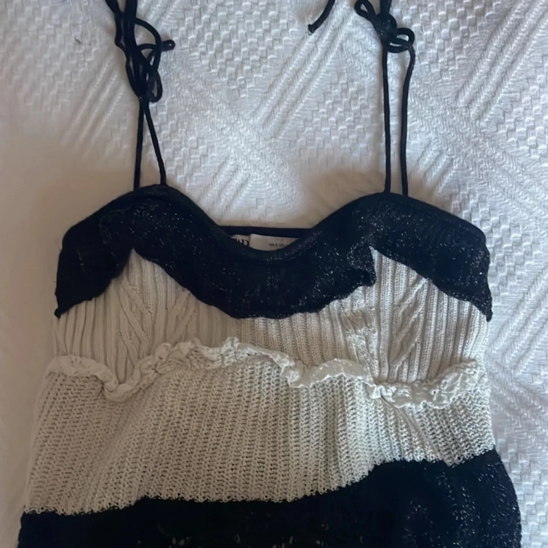 Svart och vit stickad topp med spetsdetaljer