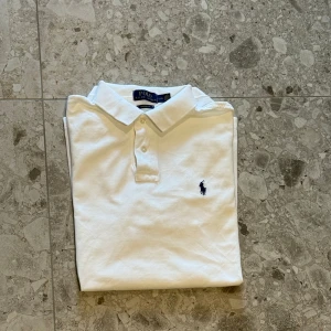 Vit piké från Polo Ralph Lauren - Klassisk vit pikétröja från Polo Ralph Lauren. Sjukt snygg piké till sommaren och nypriset på denna är på cirka 1500kr.