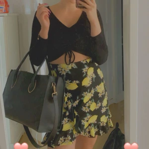 Omlottkjol - Söt svart omlottkjol med citroner. Från Gina Tricot. Storlek M. I fint skick. 