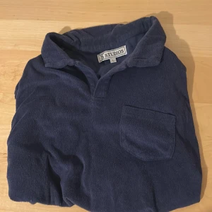 Frotté tröja  - Tja! Säljer en as snygg och superbekväm mörkblå pikétröja från ST Studios. Tröjan är gjord av mjuk  frotte på utsidan och bommull på insidan . Perfekt för en sval sommarkväll.