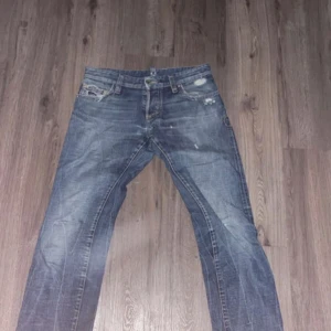 Blå dsquared2 jeans med några snygga slitningar - Dsquared2 jeans, helt nya och oanvända säljer då jag ej kan ha dom, dom är riktigt snygga med en text på baksidan och några snygga unika slitningar lite här och var