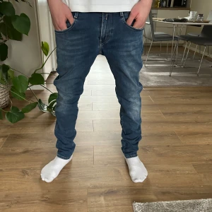 Replay Anbass Hyperflex  - Snygga blå jeans från Replay med en klassisk femficksdesign och diskreta slitningar. Märkeslogga på bakfickan ger en extra touch. W.30 L.32