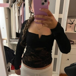 Svart spetsblus från Amisu - Snygg svart spetsblus från Amisu med lång ärm och en elegant v-ringning. Perfekt för att ge en stilren look med en touch av spetsdetaljer. Blusen har en tight passform som framhäver figuren.strl L men passar mer S. Dubbel tyg i ryggen, bysten och armarna