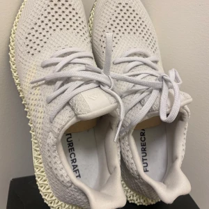 Adidas Futurecraft sneakers - Snygga och moderna Adidas Futurecraft sneakers i en stilren vit färg. Skorna har en unik 3D-printad sula och är tillverkade i ett andningsbart syntetmaterial med snörning för perfekt passform.