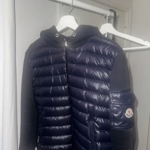 Moncler cardigan - Snygg mörkblå pufferjacka från Moncler med huva och dragkedja. Storlek M men passar S. Säljer billigt för är i behov av pengar
