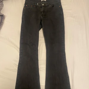 Svarta bootcut jeans - Snygga svarta bootcut jeans från Gina tricot (perfect jeans). De har en knapp och dragkedja framtill. Jeansen är däremot lite slitna längst ner.