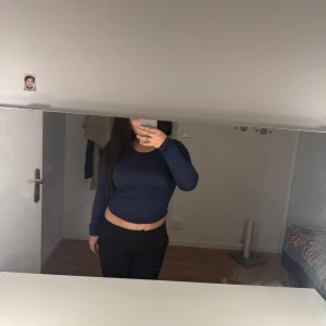 Mörkblå croppad tröja - Säljer en helt ny mörkblå croppad tröja med långa ärmar. Perfekt för en trendig look. 