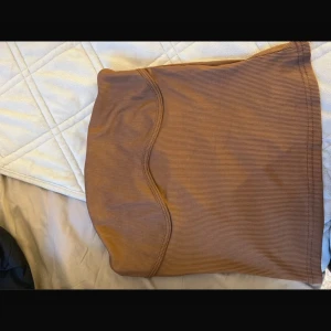 Brun ribbad kjol från SHEIN - Snygg brun ribbad kjol från SHEIN i en tight passform. Perfekt för att skapa en stilren look. Kjolen är kort och har en enkel design som gör den lätt att matcha med olika toppar.