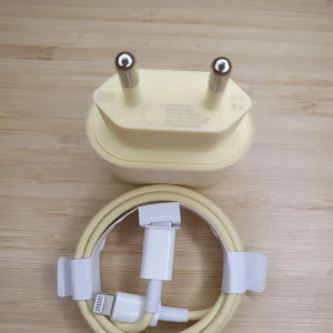 Gul laddare med kabel, XTW Lightning Quick Charging Set, 20W Charger and 33W 1m Lightning Cable - Säljer en gul laddare med tillhörande kabel. Laddaren har en kompakt design med två stift och kabeln är utrustad med en USB-C kontakt i ena änden och en Lightning kontakt i den andra. Perfekt för att ladda dina enheter snabbt och enkelt.